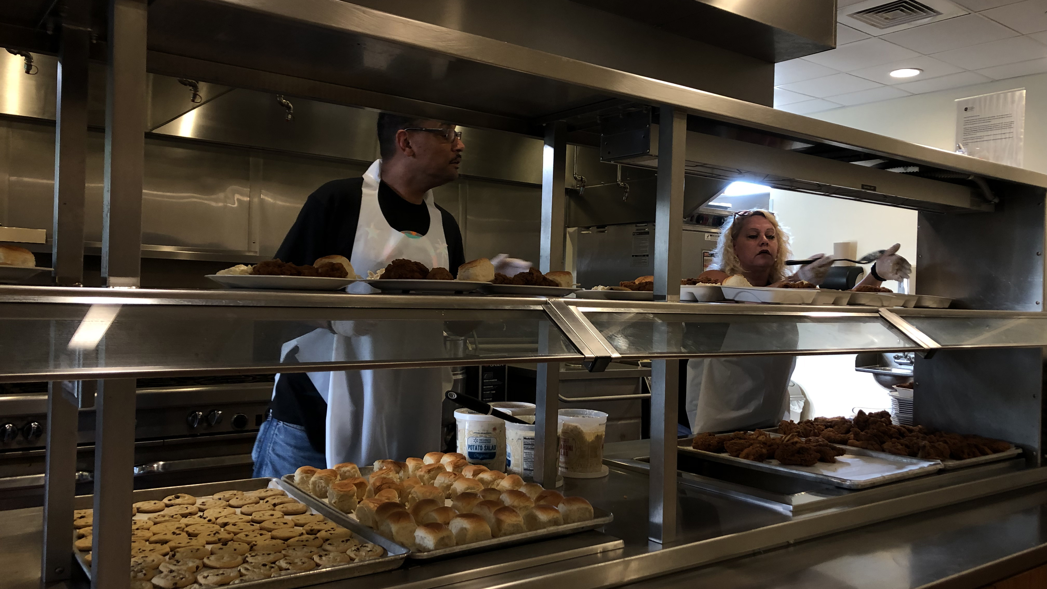 Volunteers serve foor in a kitchen.