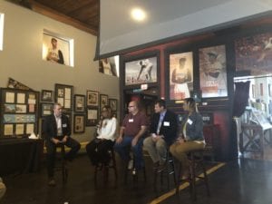 panelists listening to each other inside a museum