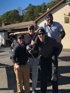 Comcasters at a golf club, one on the back of another person