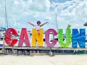 Dana Brooks behind a Cancun sign