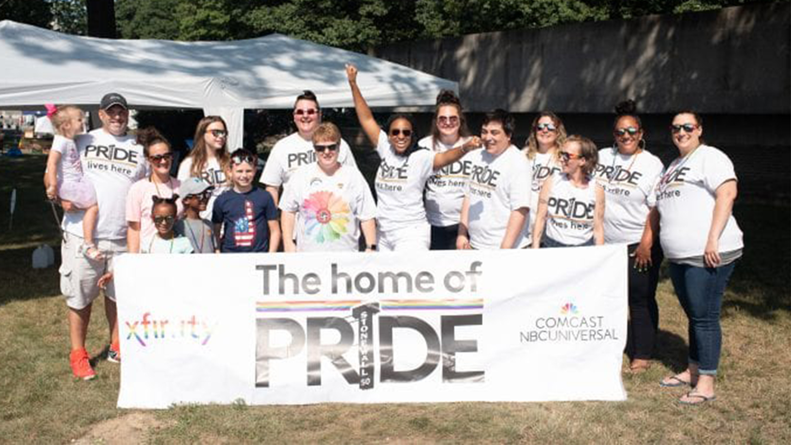 Xfinity employees hold a Pride sign.