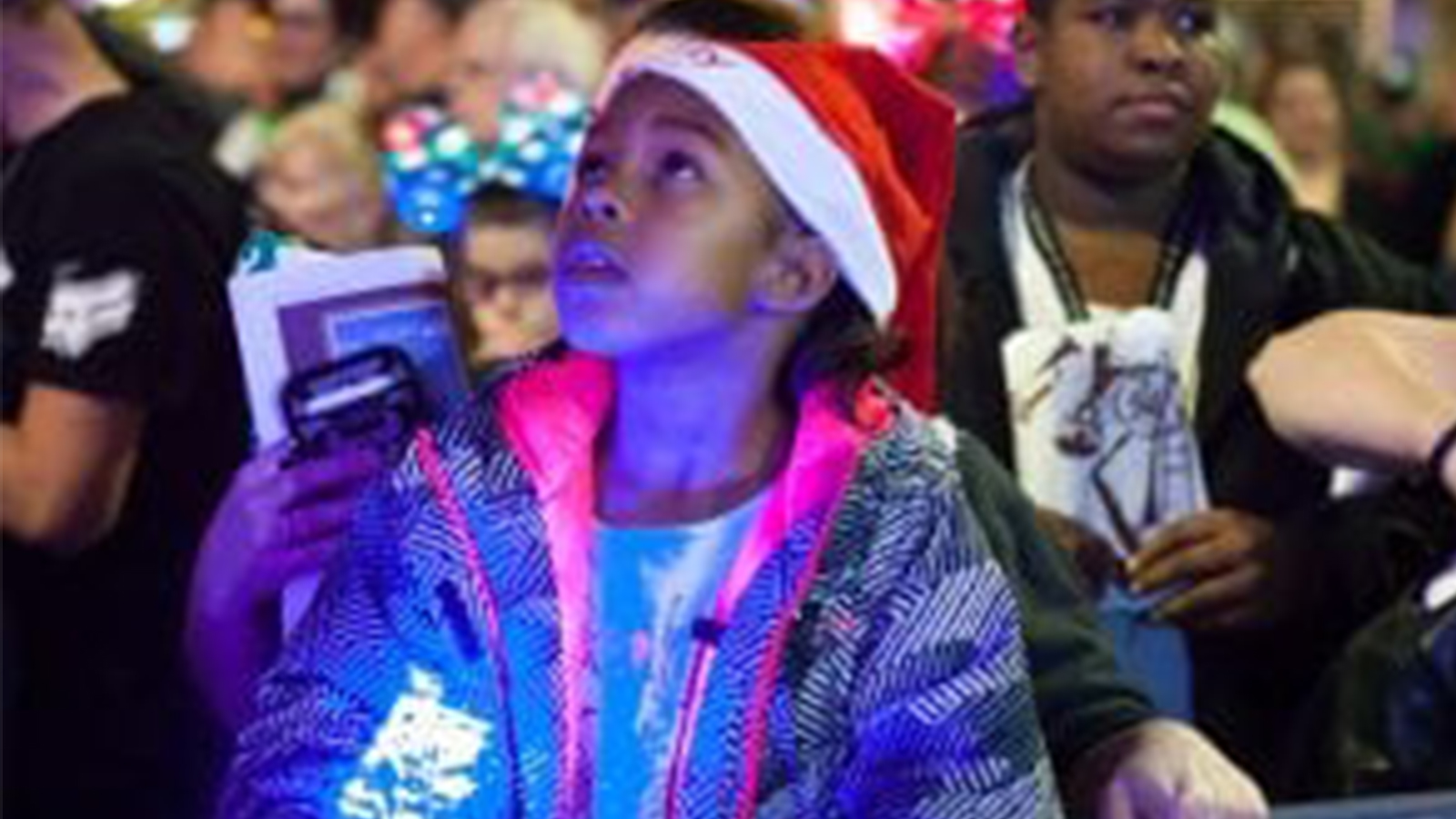 little girl wearing a Santa hat looking up