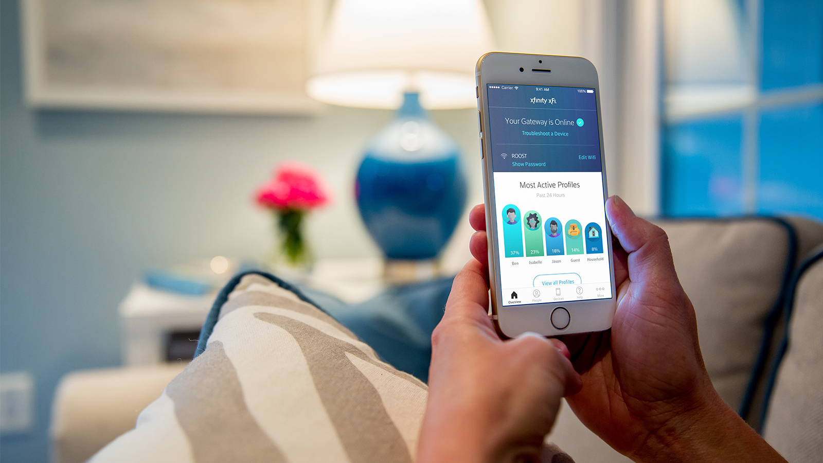 Person holding smartphone and looking at Xfinity xFi app to see which users are on their WiFi network.