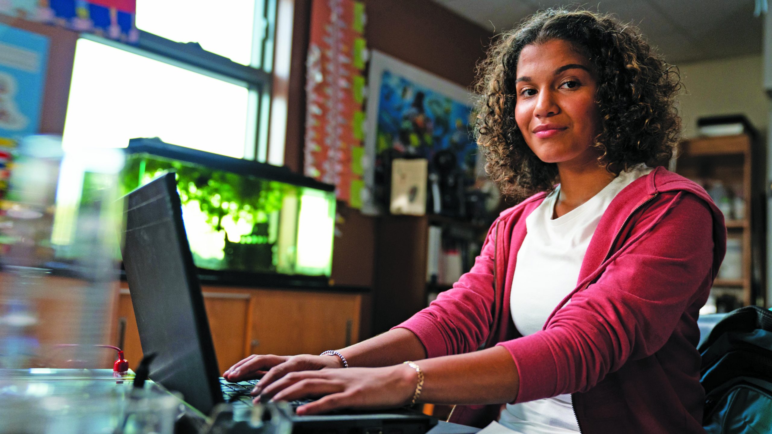 Student typing on a laptop in her bedroom