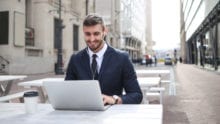 man typing on laptop outdoors