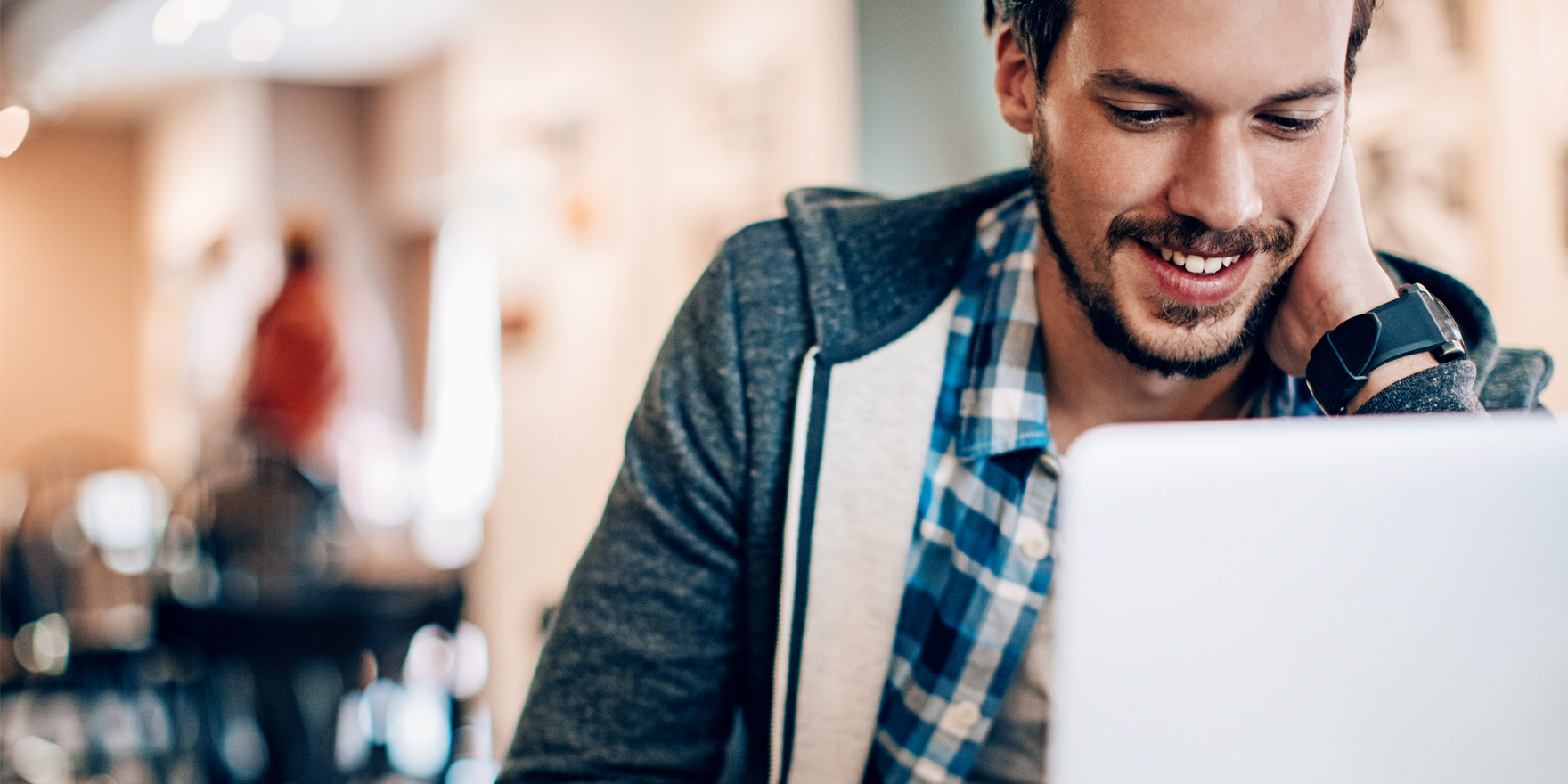 Man smiling while looking at a laptop screen