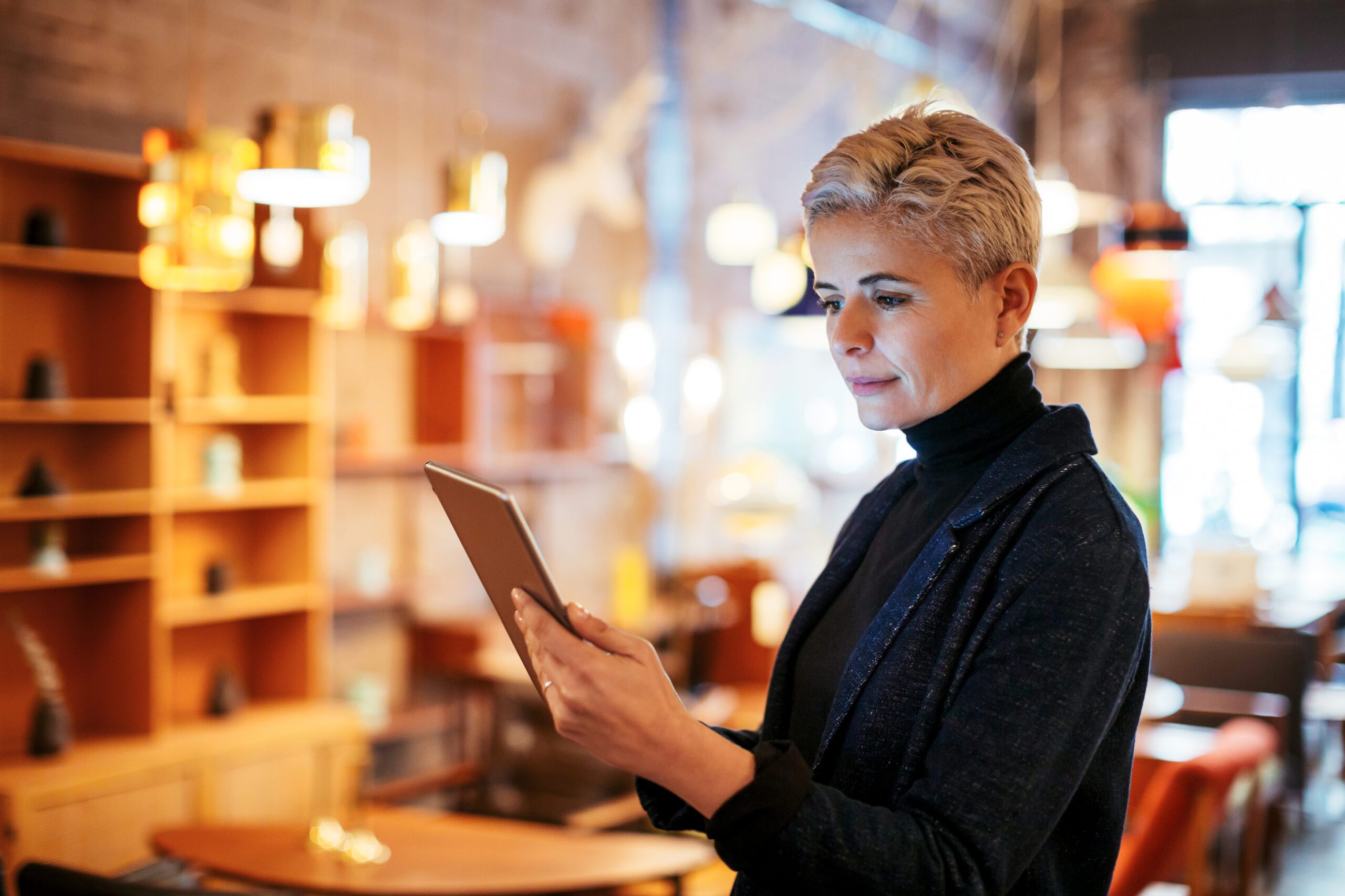 Woman looking at tablet computer inside her business