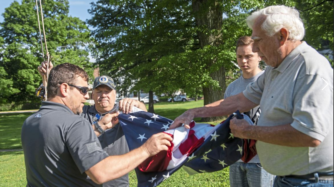 Comcast employees folding flag