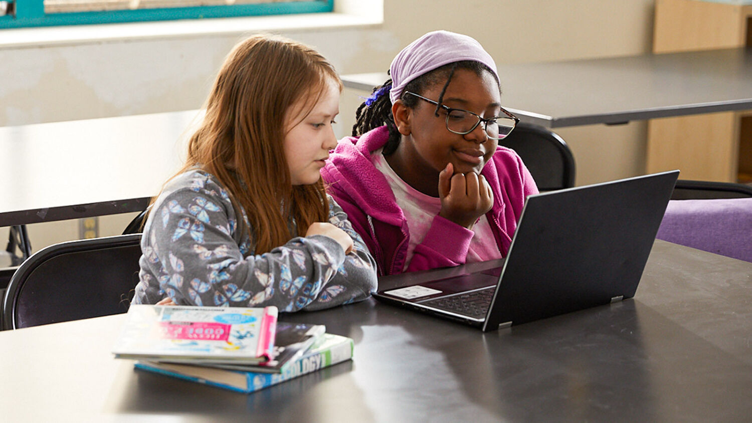 Two students working on a laptop